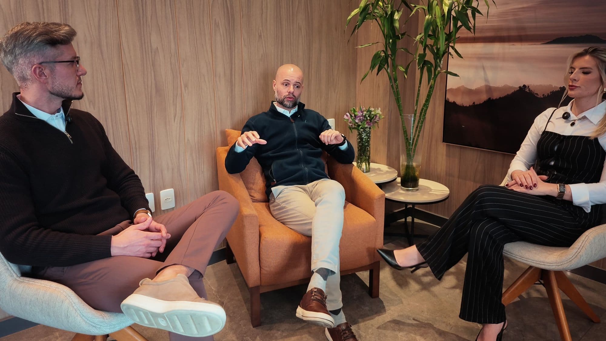 Ícaro, Paulo e Joceane conversam sentados na sala do estúdio